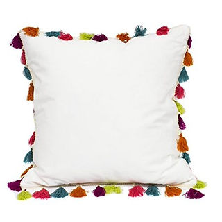 white pillow with colorful tassles