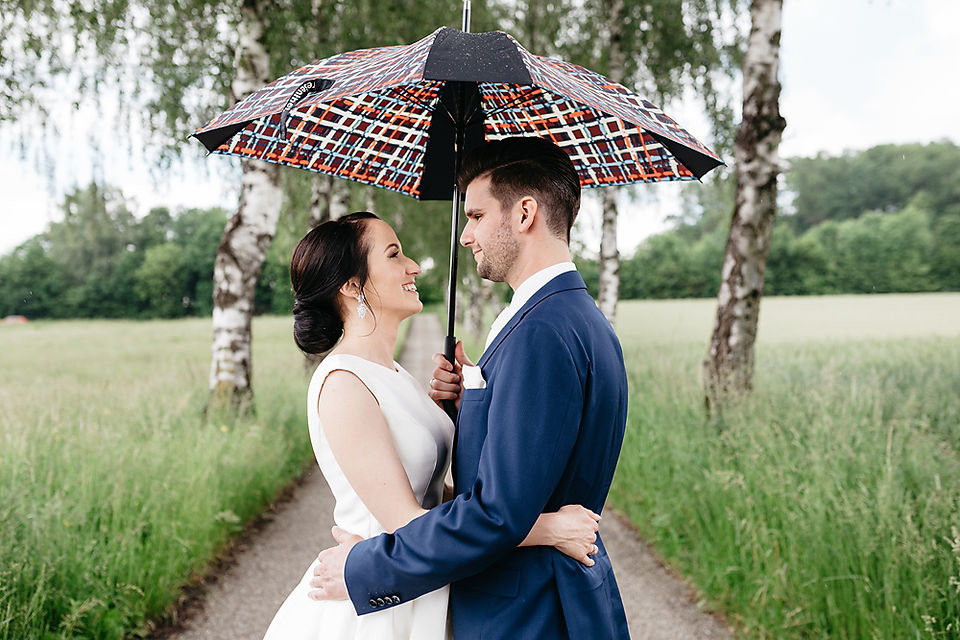Brautpaarfotos im Regen mit Regenschirm