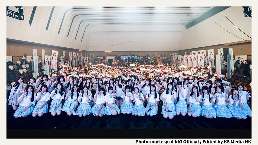 「KS Media HK」新聞圖片(IdG Official 官方提供)。IdG 一周年專場音樂會《Backyard Live》圓滿落幕的感人全員大合照。多達 42 位的 IdG 成員身穿整齊的日系格子裙制服舞台裝,在舞台前方蹲下、排成一橫列比出 V 字手勢微笑。背景為座無虛席的 AXA Dreamland 音樂廳看台,熱情粉絲高舉應援手幅、燈牌,兩側排滿了個人巨型直幡。圖片右下方帶有「Photo courtesy of IdG Official / Edited by KS Media HK」字樣。
