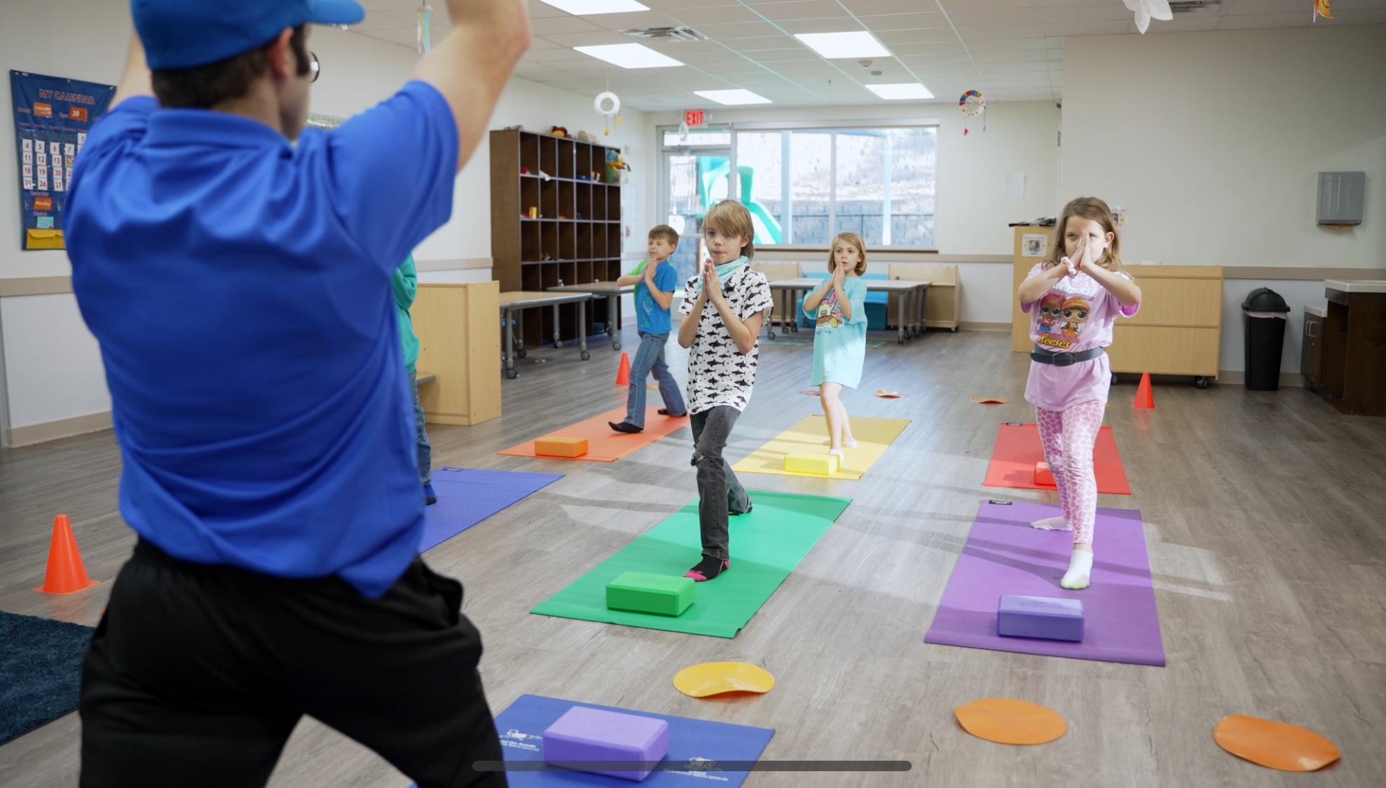 Preschool children practicing balance on colorful equipment in class
