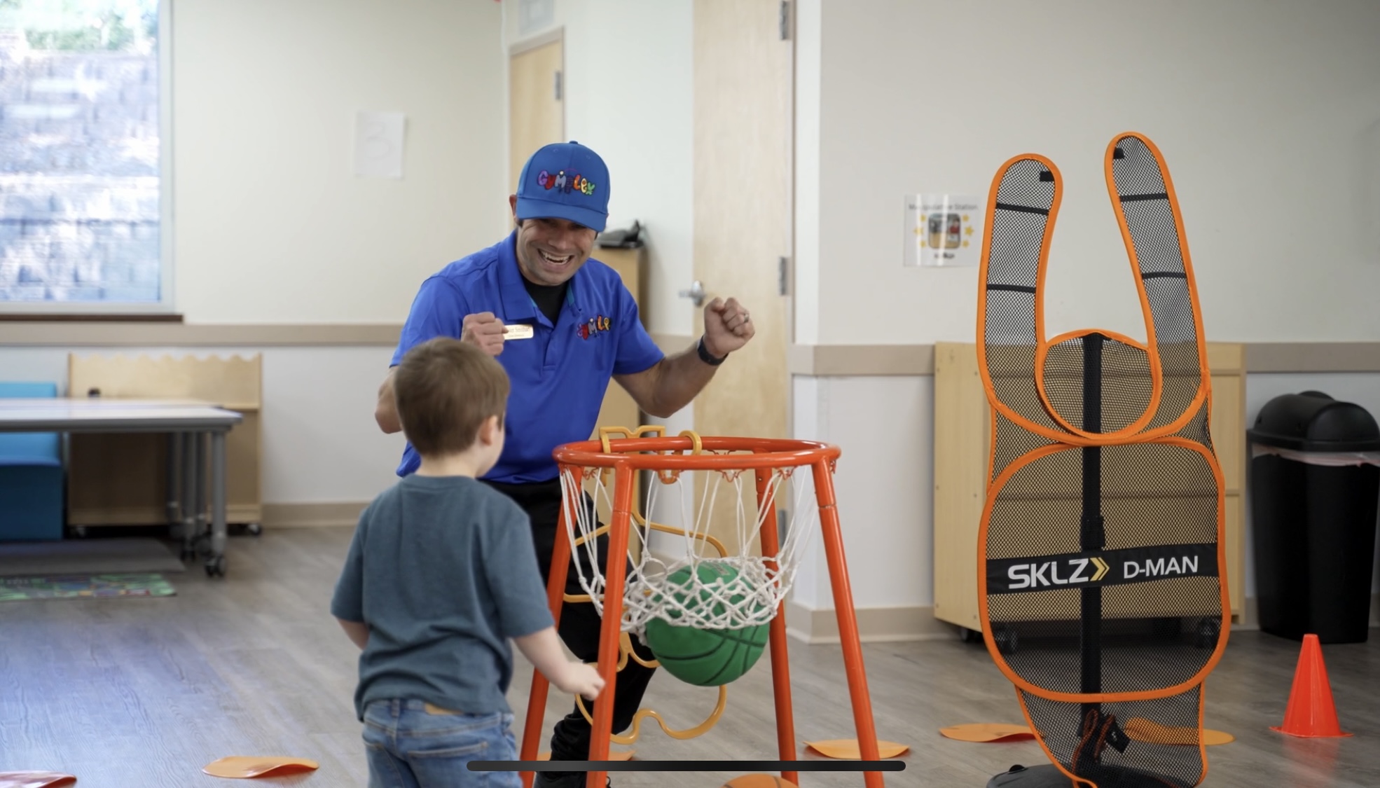 A child practicing basketball with a Gymplex coach