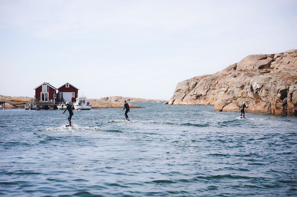 Tre personer surfar tillsammans under en eFoil-lektion på Smögen med eFoil Sweden.