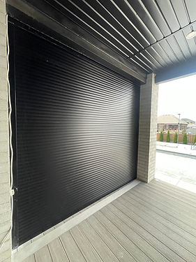 Residential roll shutters installed over multiple home openings including windows and pati