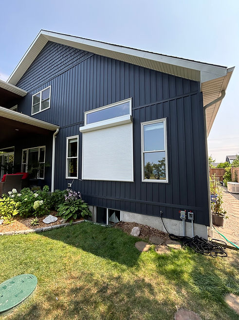 Modern Canadian home with aluminium roll shutters installed over large windows in winter.
