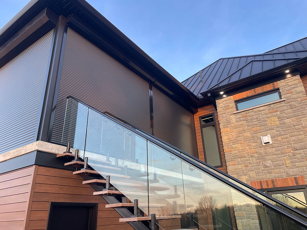 Roll shutters closed on elevated patio with glass railing and exterior staircase