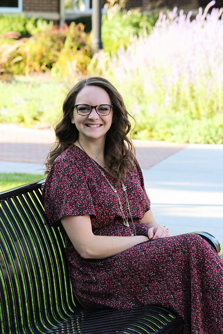 Kristin M Sorensen Headshot Sitting on a Bench