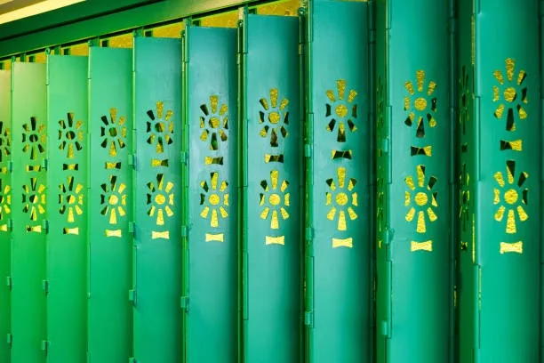 Green folding shop gate with cut-out patterns
