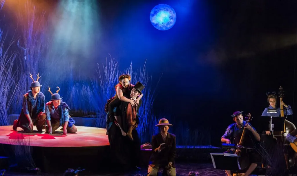 a group of performers on stage, close to a few opera musicians