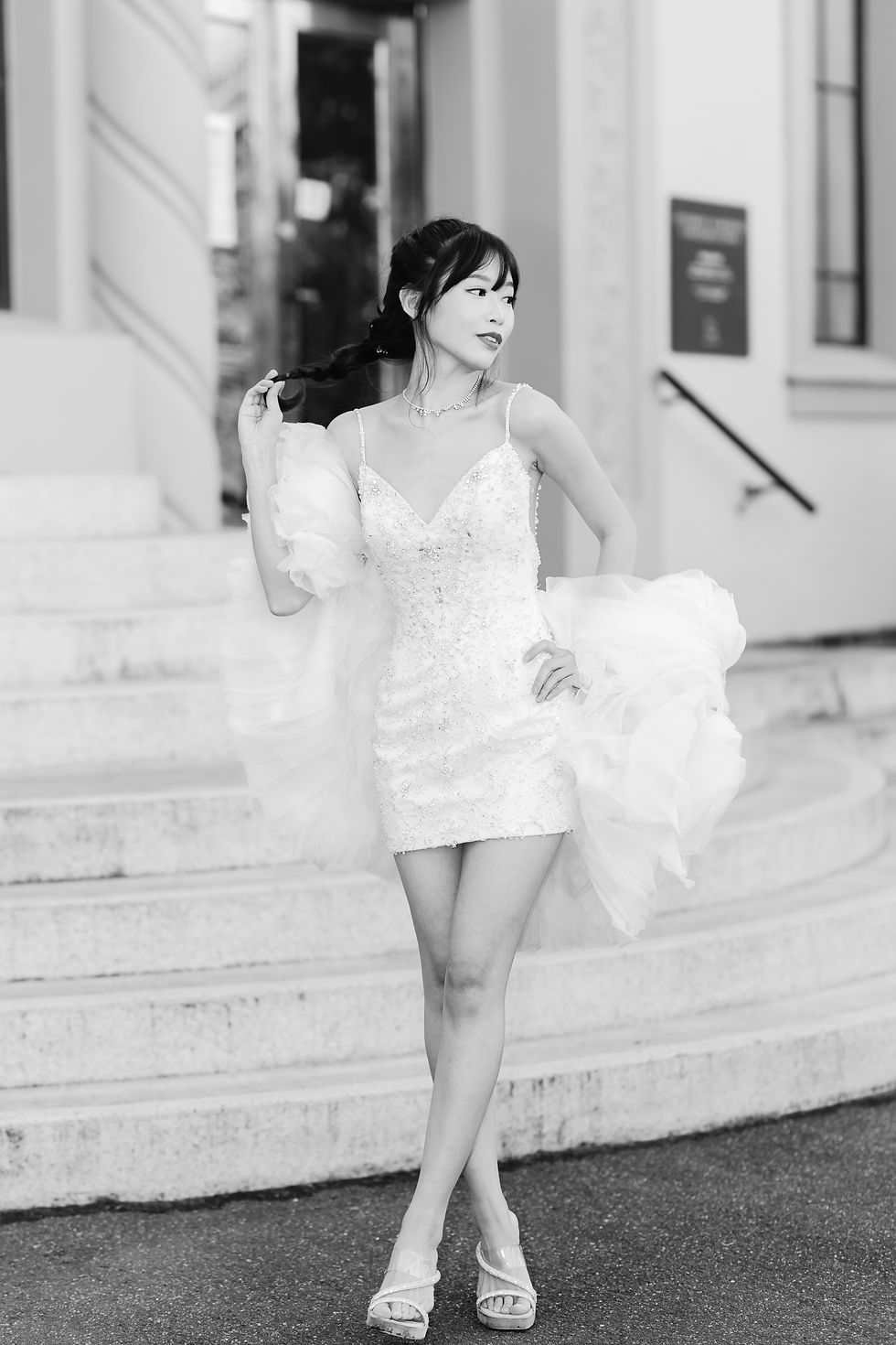 bride in mini dress standing in front of steps