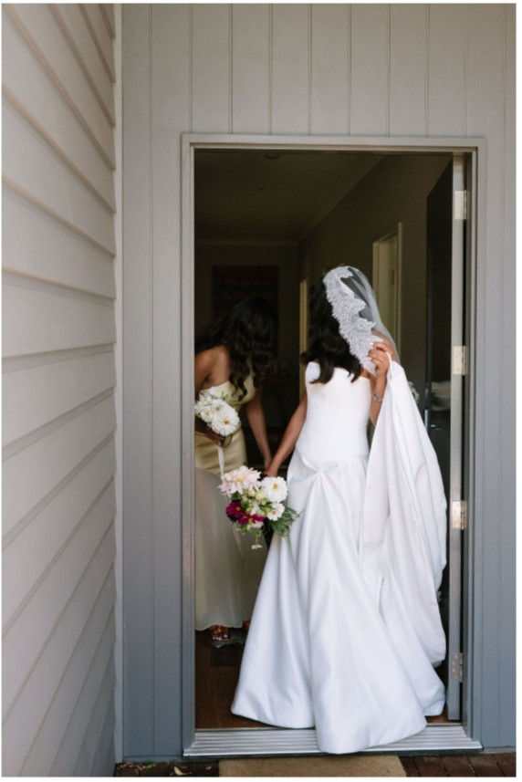 Back view of KYHA Aspen duchess satin wedding gown with chapel train and drop waist