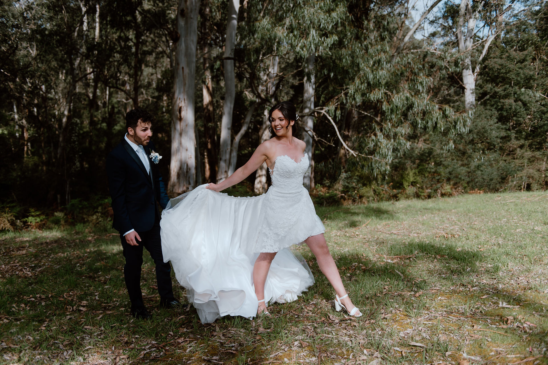 Bride removing her overskirt. Groom looking on in surprise