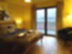 Master bedroom with patio doors out onto the waterfront balcony at Glengoulandie Holiday Lodges