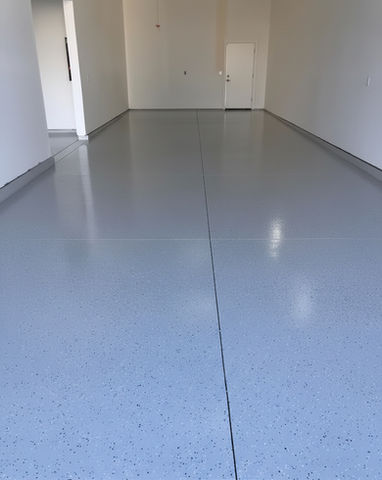 Newly coated garage floor, light blue, ready for use, with open door.