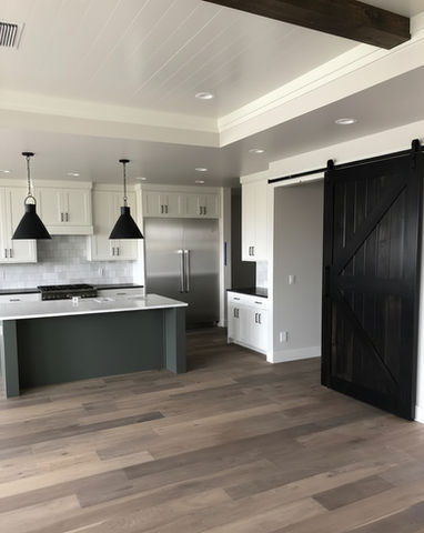 Modern kitchen with white cabinets, island, black door and lights.