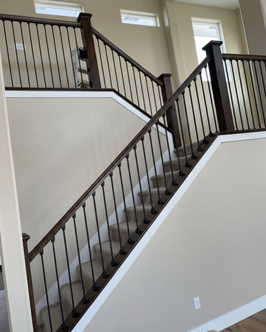 Staircase with wooden handrails and spindles leading upwards in a home setting.