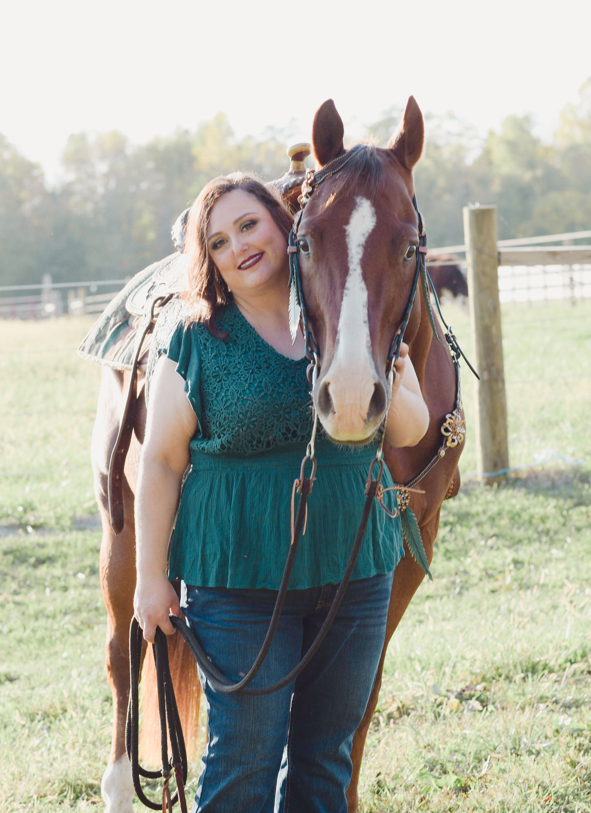 Horse and rider image of a woman holding her chestnut gelding in western tack.