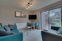 Modern living room with blue chairs and wall art.