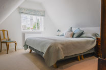 Cozy bedroom with large bed and window view.