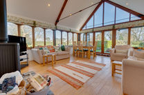Cozy living room with large windows and wooden beams.
