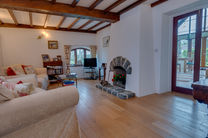 Cozy living room with fireplace and wooden beams.