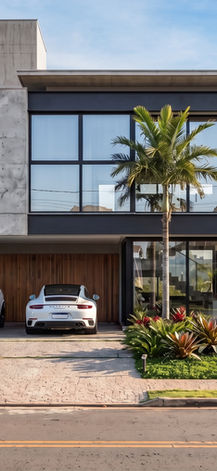 Fachada da Casa FR com acesso à garagem e revestimento em madeira, Garopaba Internacional