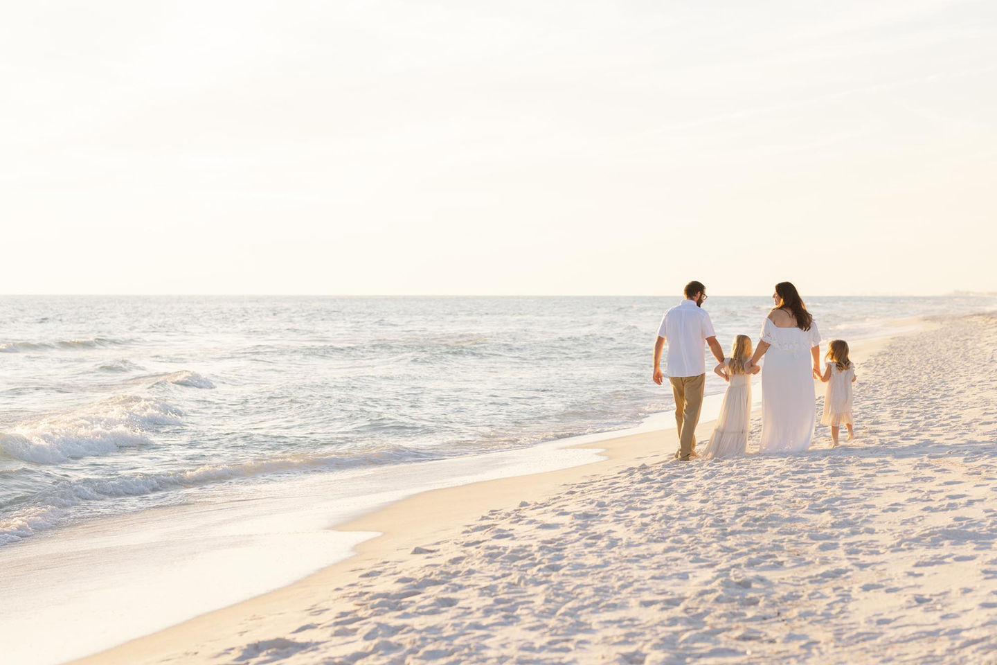 Family of 4 walking on beach