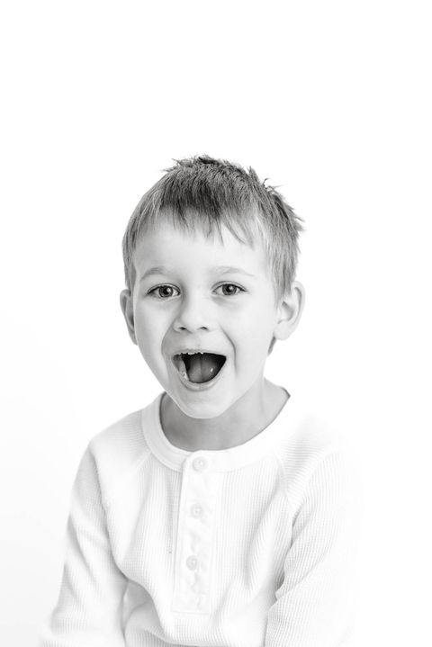 Black and white of blond boy making silly face