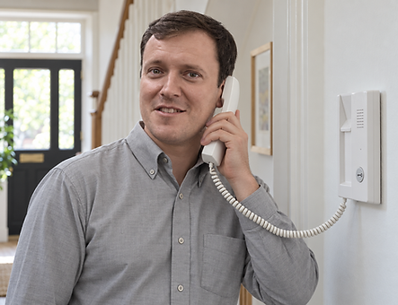 Battersea Locksmiths team member using an indoor door-entry intercom handset.