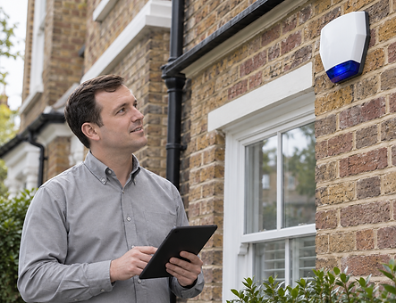 Battersea Locksmiths team member inspecting an exterior burglar alarm bell box.