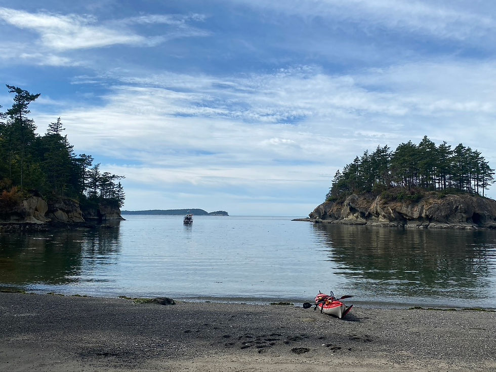 kayak resting on a beach ready to launch under blue skies