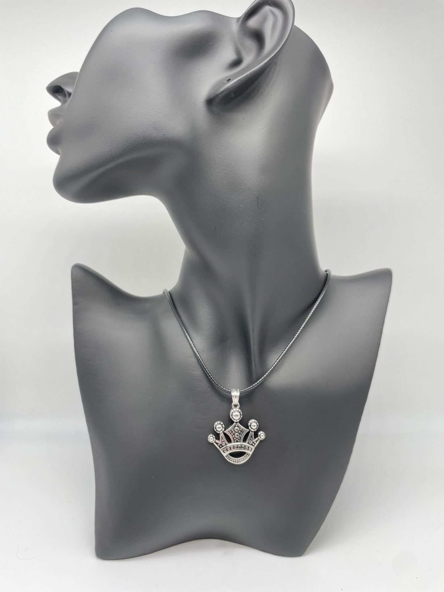 Stainless steel pendant featuring a crown design.