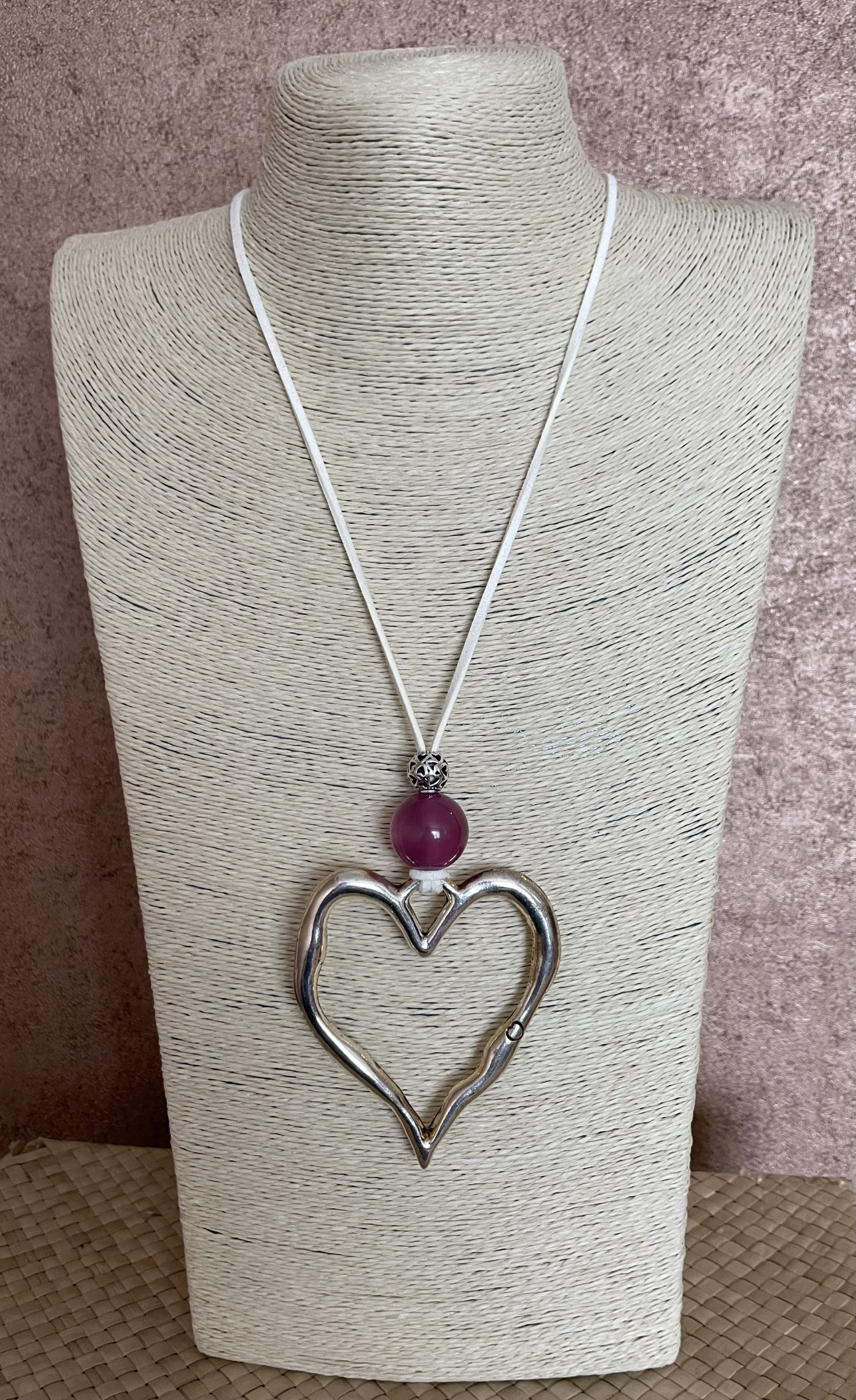 Long Necklace on off white cord featuring large metal heart with pinky purple acrylic and metal bead.
