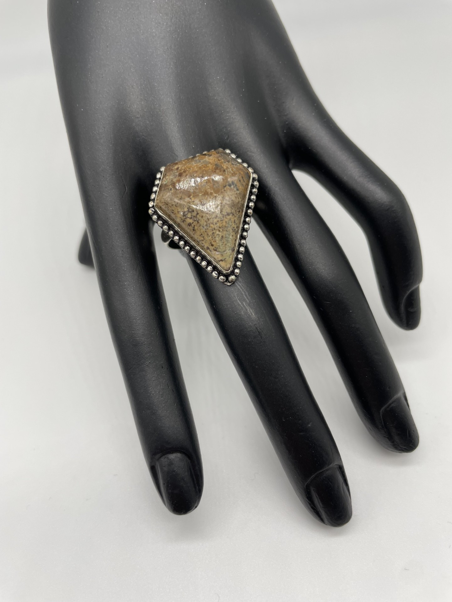 This unusual kite shaped ring features Jasper. The edging to the ring is simple leaving allowing the stone itself to be the full focus. This ring is neutral earthy brown tones which means it will suit any outfit and is perfect for the current boho look.