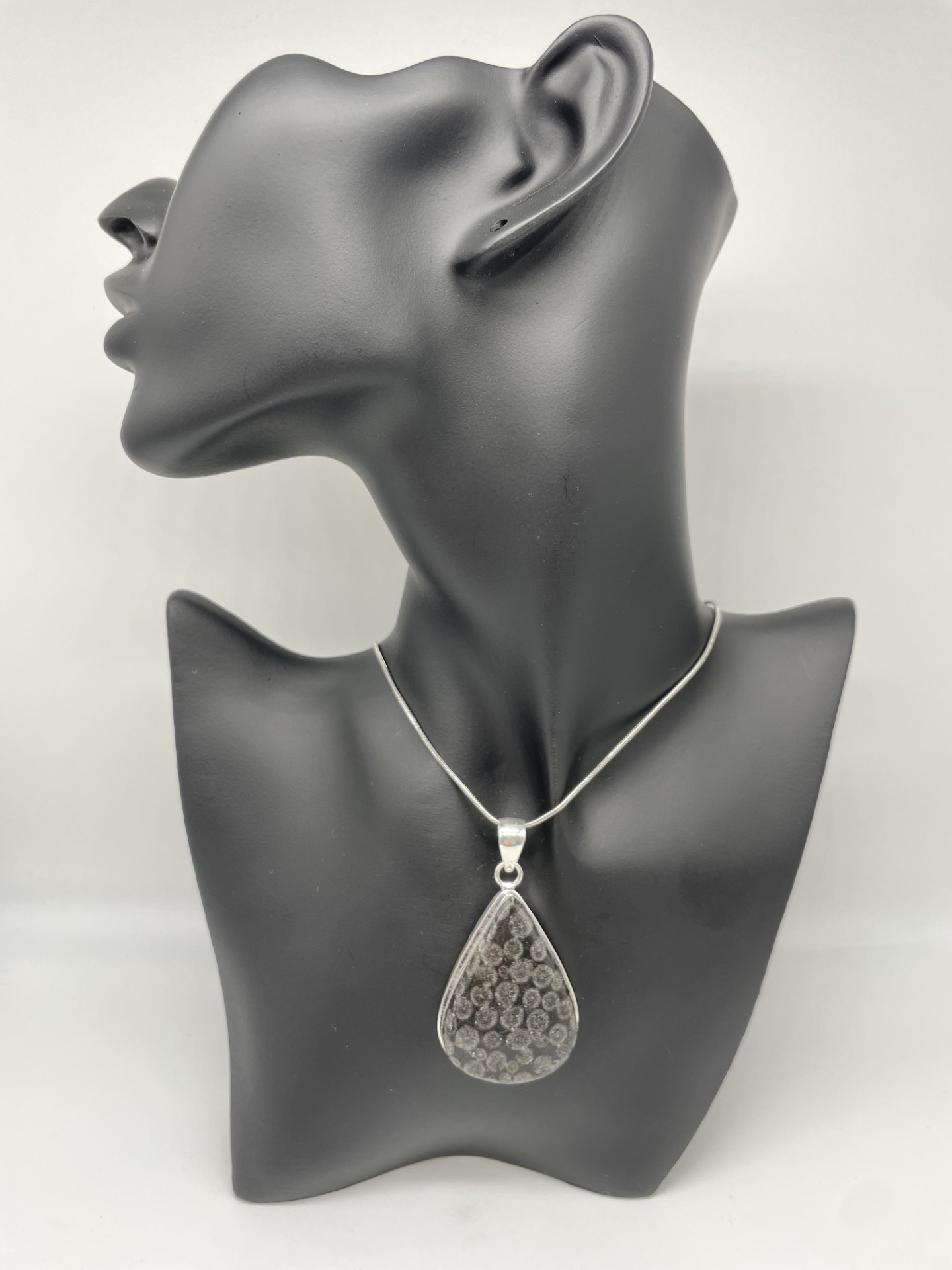 Very interesting fossil coral stone in black/grey tones. The stone is a teardrop shape in a simple classy setting. A piece you will wear and wear and a great choice for a present when you are not sure what colours the recipient favours.