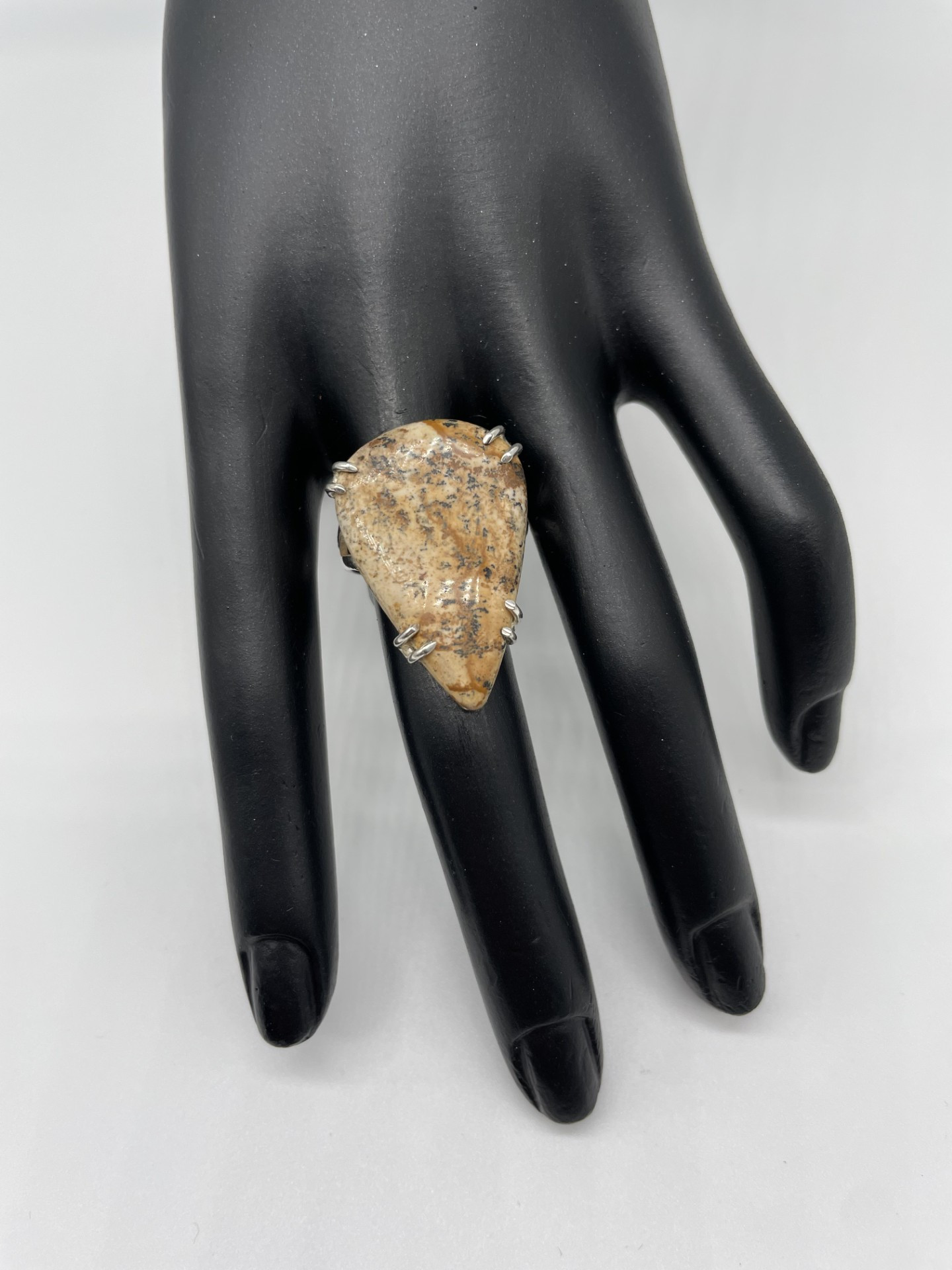 This larger style ring has no border on the ring around the gemstone, instead it is mounted in a very subtle claw setting. The Picture Jasper gemstone features earthy brown tones.
