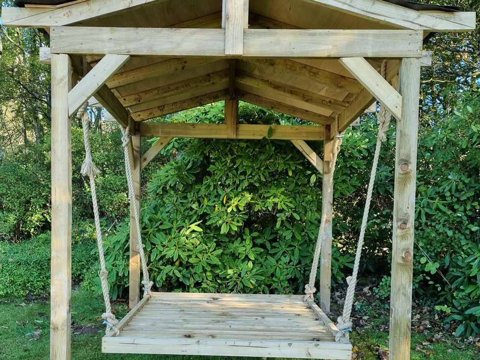 Front view of rustic timber swing bed pavilion with gable roof in Cumbria garden