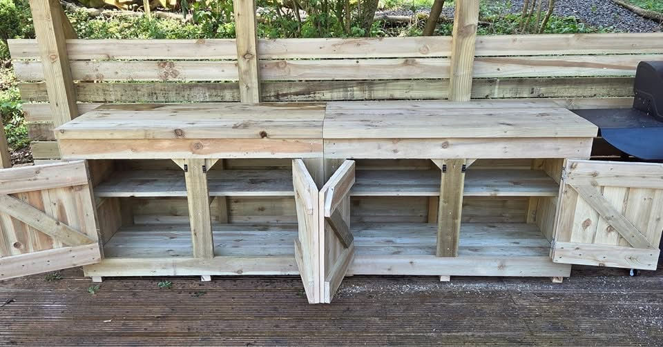 Timber outdoor kitchen cabinets with open double doors and internal shelving, built for garden storage and BBQ use