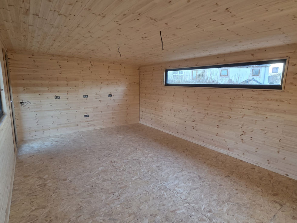 First-fix garden room interior with ribbon window, exposed socket wiring and timber cladding, Cumbria