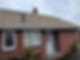 A house featuring a tiled roof and a chimney