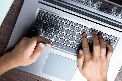 Hands holding credit card and using laptop