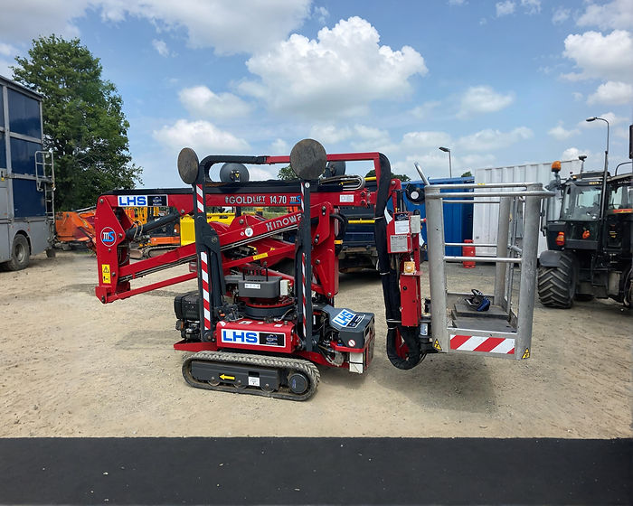A red and black tracked platform lift in a gravel lot, with "LHS" and "GOLDLIFT 14.70" labels