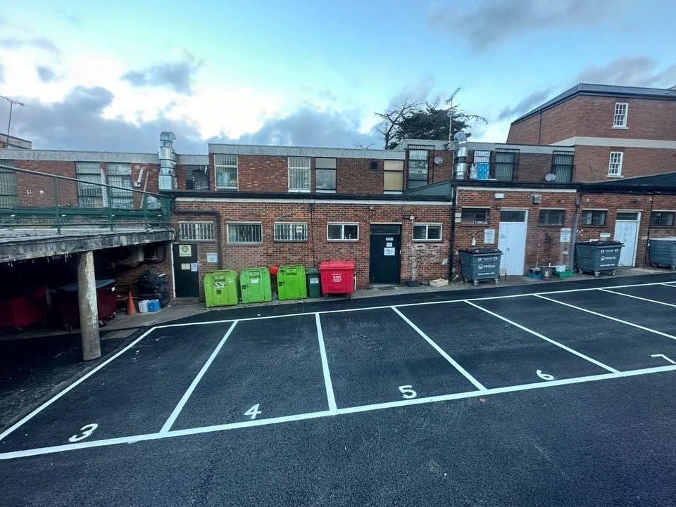 A row of numbered parking spaces in front of a brick building