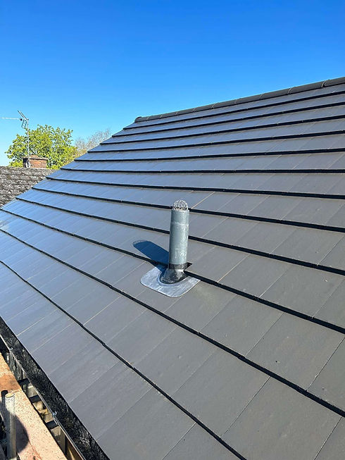 The image shows a gray interlocking flat roof tile installation