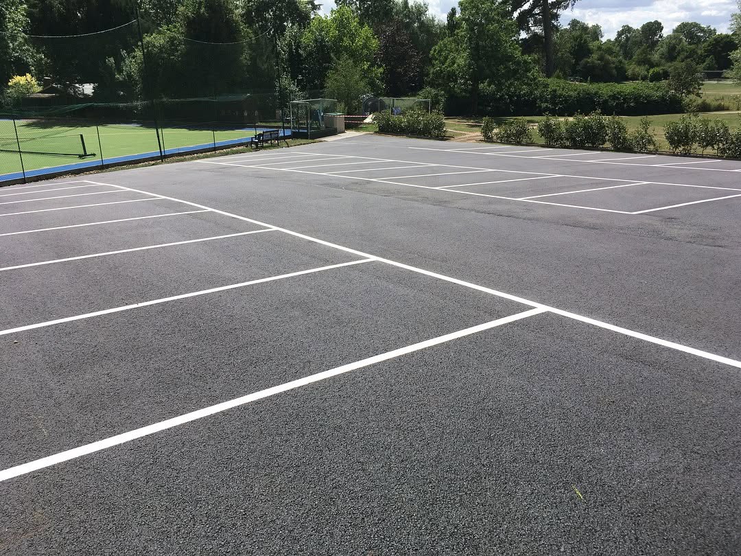 A tennis court featuring clearly marked white lines on a green surface