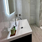 A modern bathroom featuring a large marble wall, sleek fixtures, and contemporary design elements