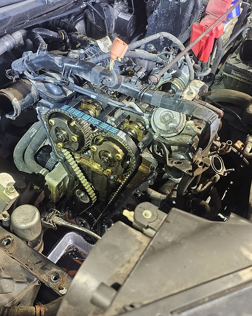 Exposed car engine displaying detailed view of timing chain and gear assembly