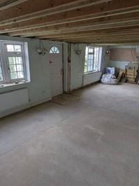 A partially built kitchen showcasing a spacious window and ongoing ceiling work