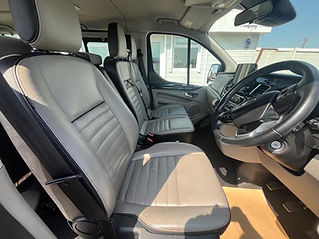 Interior view of a van featuring plush leather seats in a spacious layout