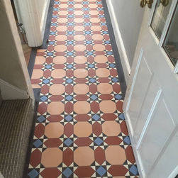 Traditional red and blue star pattern geometric tiled floor in a bright domestic hallway