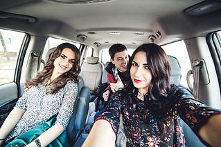 Girls and guy taking selfie in car